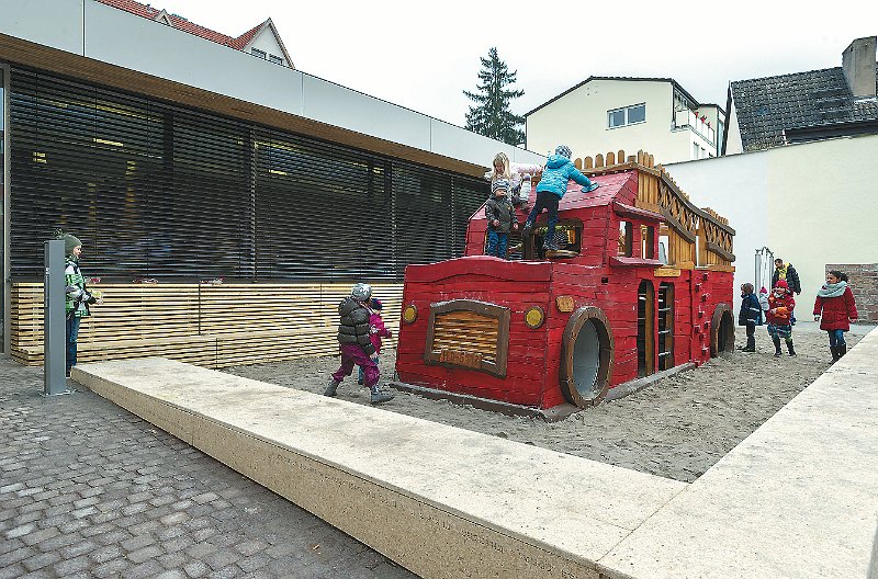JRB_12_Neuenheim_2sp.jpg - Dezember: Das Bürgerzentrum am Neuenheimer Marktplatz wird eröffnet. Gleich beleben die Kinder das Spiel-Feuerwehrauto vor dem Neubau. (Foto: Rothe)