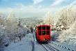 Die Bergbahn erklimmt den winterlichen Königstuhl in knallroter Pracht – Weihnacht auf Gleisen