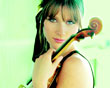 In grünes Licht getaucht sieht man Lisa Batiashvilli mit ihrer Geige