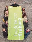 Das Festival-Team des Heidelberger Frühlings hält eine Fahne in den Händen.