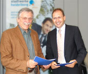 Albertus L. Bujard, 1. Vorsitzender von Obdach e.V., und Michael Teigeler, Geschäftsführer der Stadtwerke Heidel­berg Energie mit den Verträgen 
