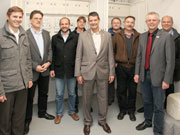 Gruppenfoto der Schweitzer Stadtwerke-Delegation und der Heidelberger Gastgeber in einem Elektrotechnik-Raum der Heidelberger-Bahnstadt