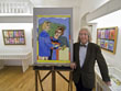 Museumsleiter Egon Hassbecker mit einem Gemälde von Josef Wittlich in den Ausstellungsräumen.