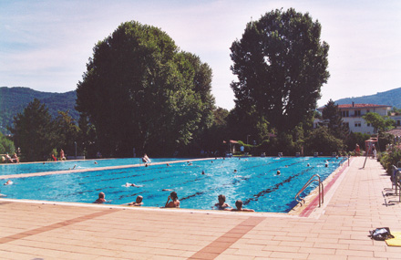 Auf dem Foto ist ein Schwimmbecken mit Badegästen abgebildet.