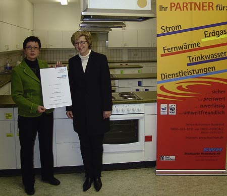 Heike Kunth überreicht eine Urkunde in der Lehrküche der Volkshochschule Heidelberg.