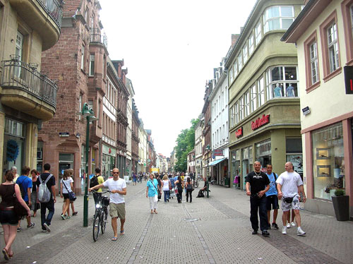 Die Hauptstraße in Höhe der Märzgasse mit den typischen Pflasterstreifen und den grünen Straßenlaternen. 