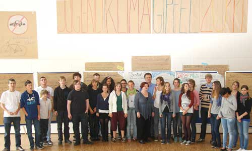 Die Gruppe der 25 Jugendlichen vor einem handgemalten Banner mit der Aufschrift Jugendklimagipfel 2011 