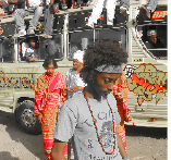 K'naan, Hip Hopper aus Somalia, vor dem buntbemalten Bandbus