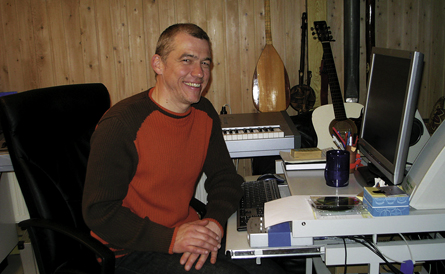 Auf dem Bild ist Jürgen Winkler in seinem Heimstudio vor dem PC zu sehen. Im Hintergrund sind diverse Instrumente.