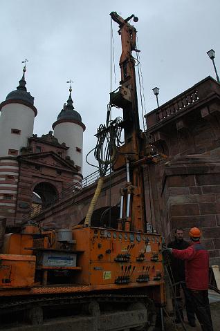 09.JPG - Dieses Bild täuscht. Der Bohrturm ist nicht einmal halb so hoch wie die Türme am Kopf der Alten Brücke. Dennoch sind auch die Bohrtürme vom Dezember 2008 bis zum März 2009 nicht aus dem Stadtbild wegzudenken. (Foto: Stadt Heidelberg)