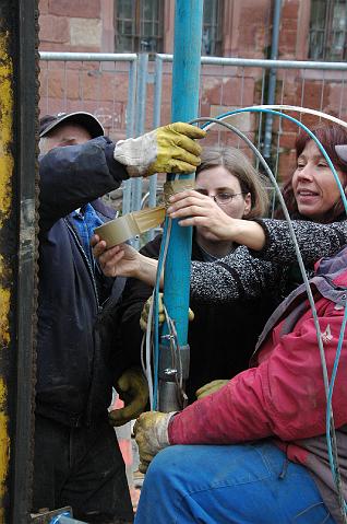 25.JPG - Damit sich die Kabel im Bohrloch nicht verfangen oder abreißen, werden sie mit Klebeband am Rohr befestigt. (Foto: Stadt Heidelberg)
