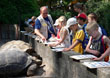 Kinder der Zooschule mit Betreuer vor dem Schildkrötengehege.
