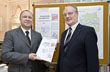 Erster Bürgermeister Bernd Stadel nimmt den Grundstücksmarktbericht 2010 vom Vorsitzenden des Gutachterausschusses Manfred Ruf (rechts) entgegen.