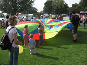Kinder spielen mit einem bunten Fallschirm