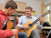Kersten Müller (rechts) beim Gitarrenunterricht in der Musikschule.