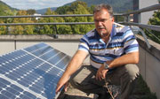 Der Lehrer Martin Hammerich neben einem Solarpanel auf dem Schuldach