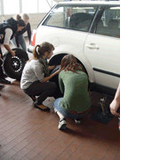 Mädchen beim Reifenwechseln in der Kfz-Werkstatt des Amt für Abfallwirtschaft und Stadtreinigung