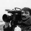 Aleksandr Sokurov mit Filmkamera auf der Schulter.