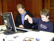 Praktikant Nils Steinbrenner beim Schreiben am Computer mit Schulbegleiter Ralf Baumgärtner 